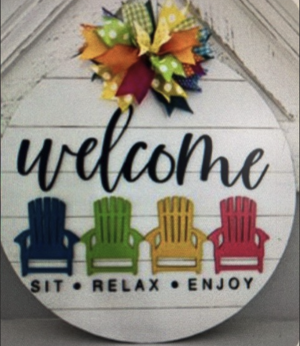 Image of the craft featuring a round wooden board with colorful chairs and bow and says welcome. 