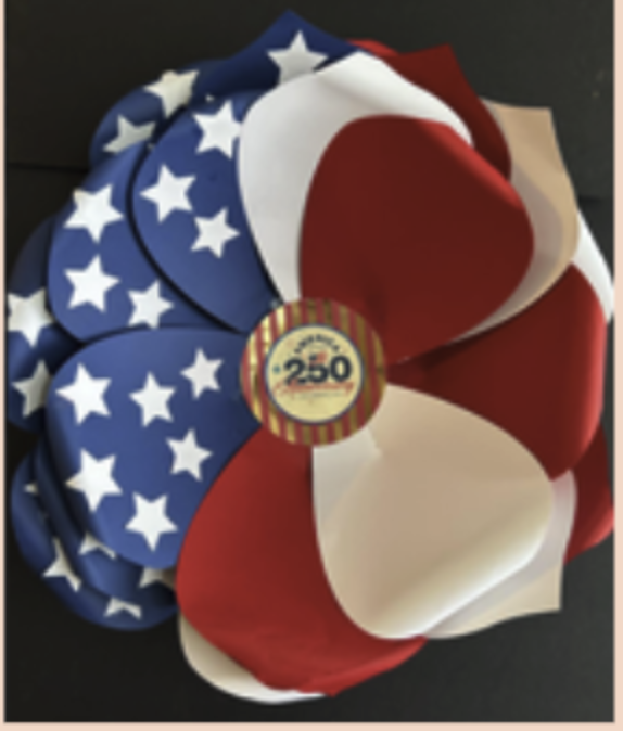 Image of a flower made with red, white and blue with stars crepe paper. 
