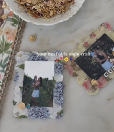 Photo frames with flower designs on them laid on a marble table.